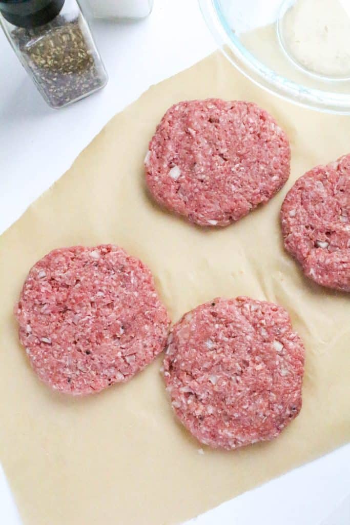 homemade hamburger patties on a piece of brown parchment paper