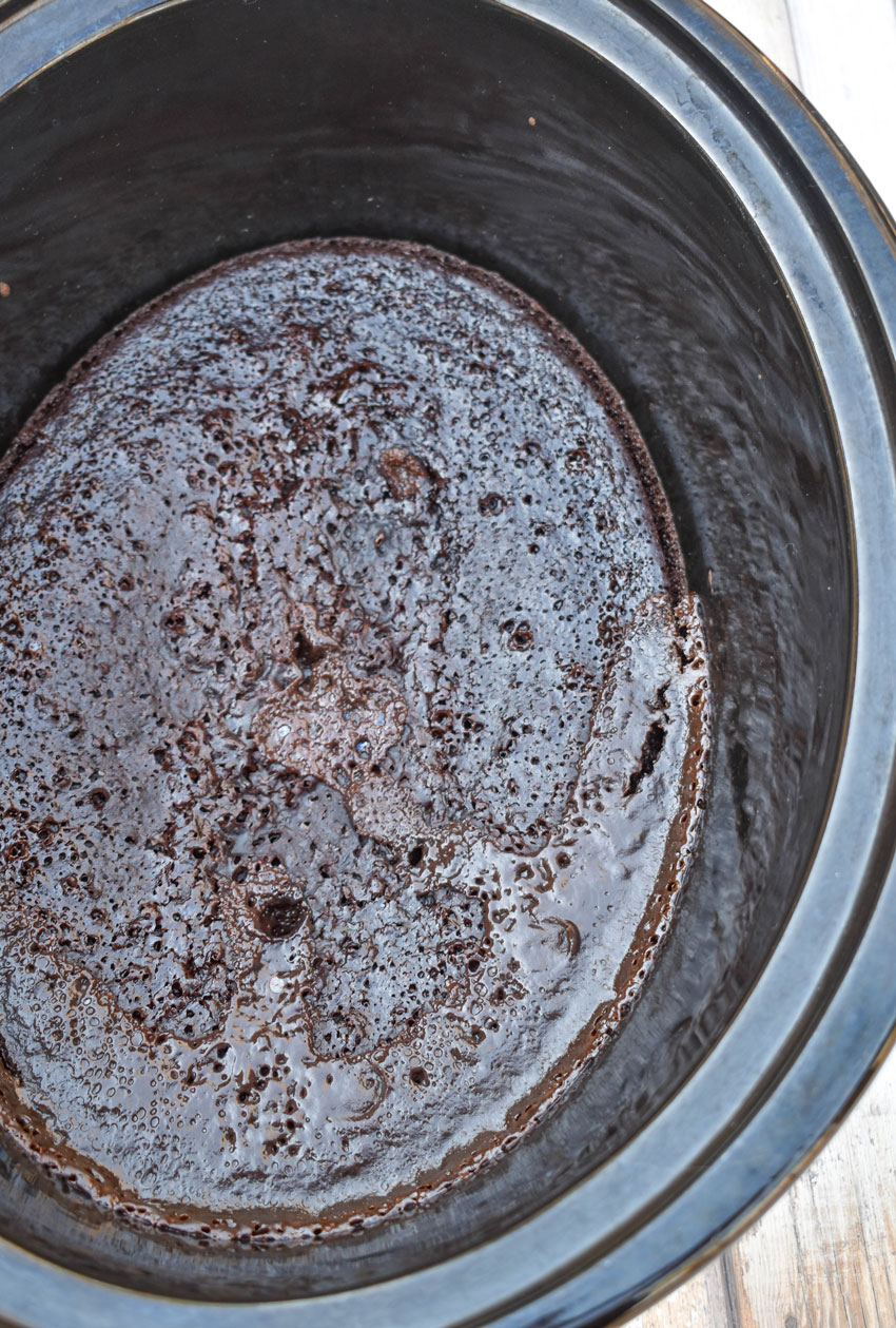 chocolate lava cake in the black bowl of a slow cooker