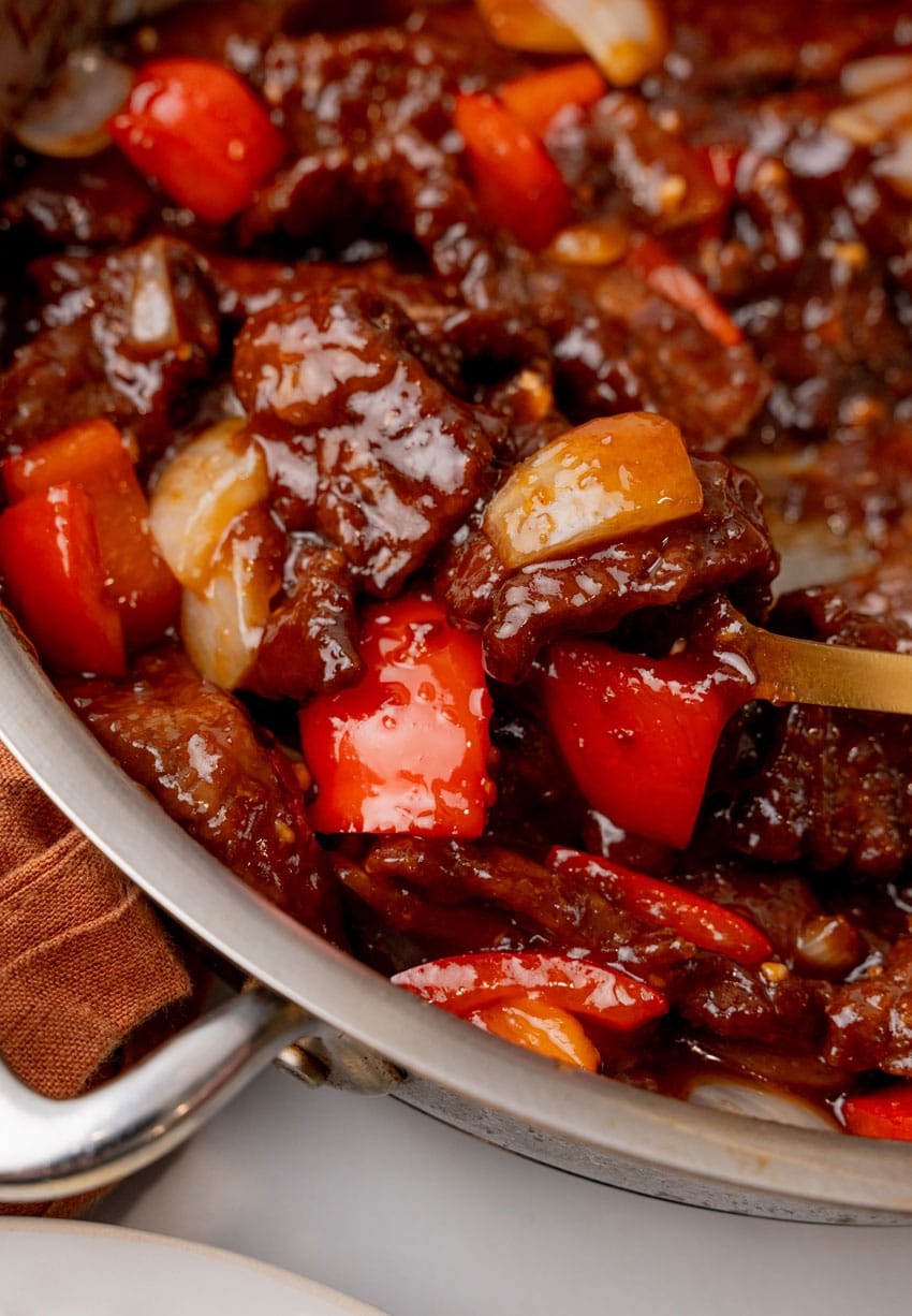 a closeup of homemade beijing beef in a metal skillet