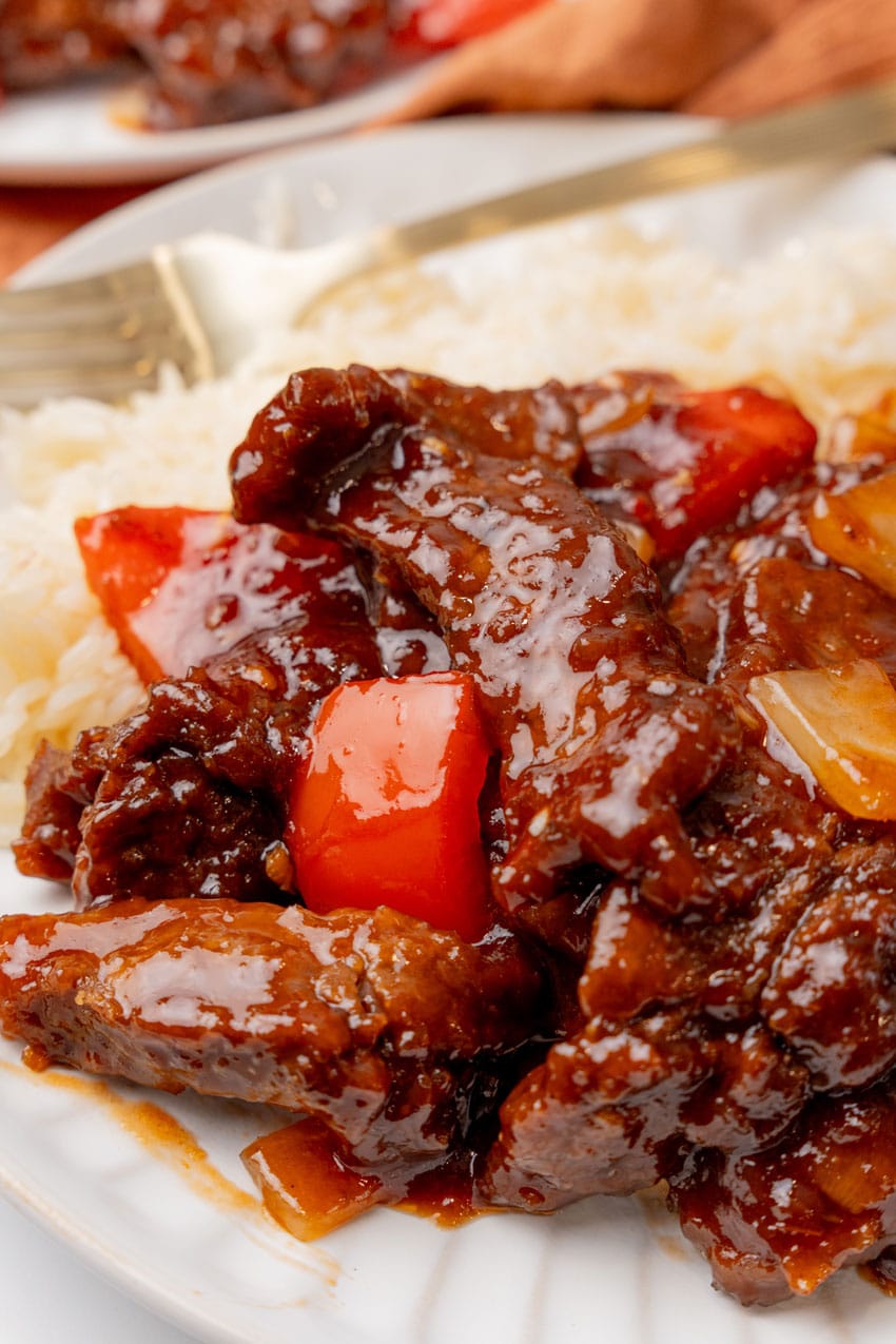 a closeup of homemade beijing beef on a white plate