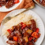 homemade beijing beef next to steamed white rice on a white plate