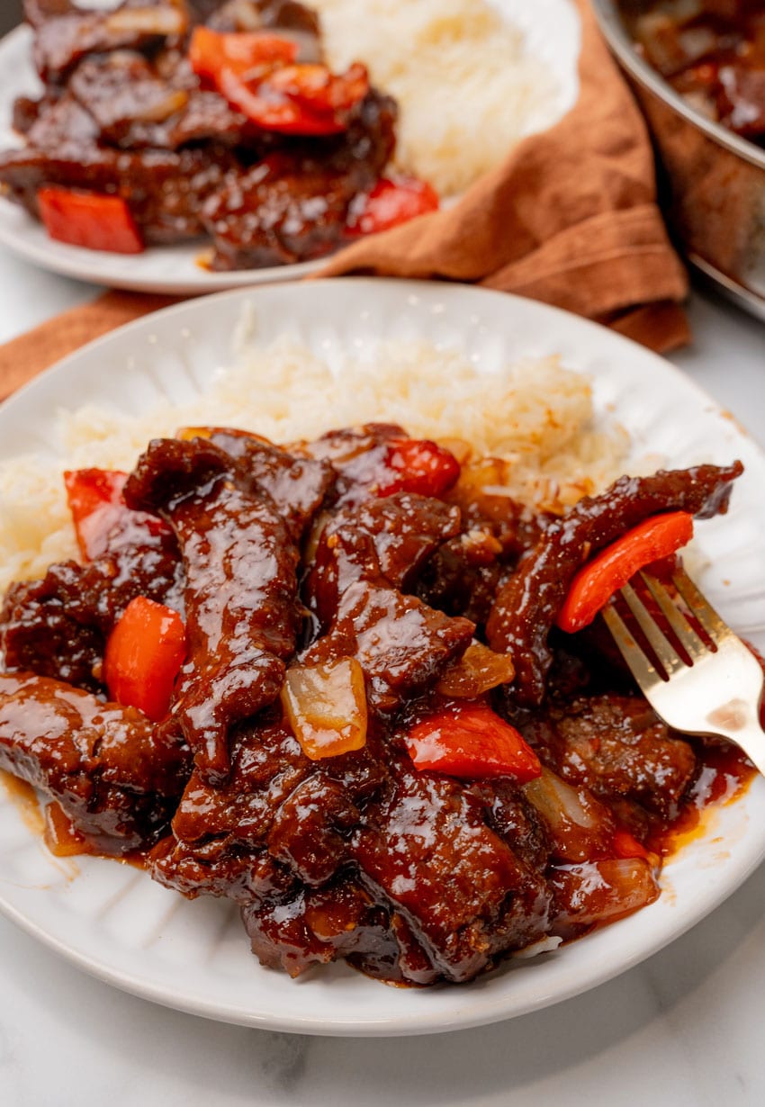 homemade beijing beef next to steamed white rice on a white plate