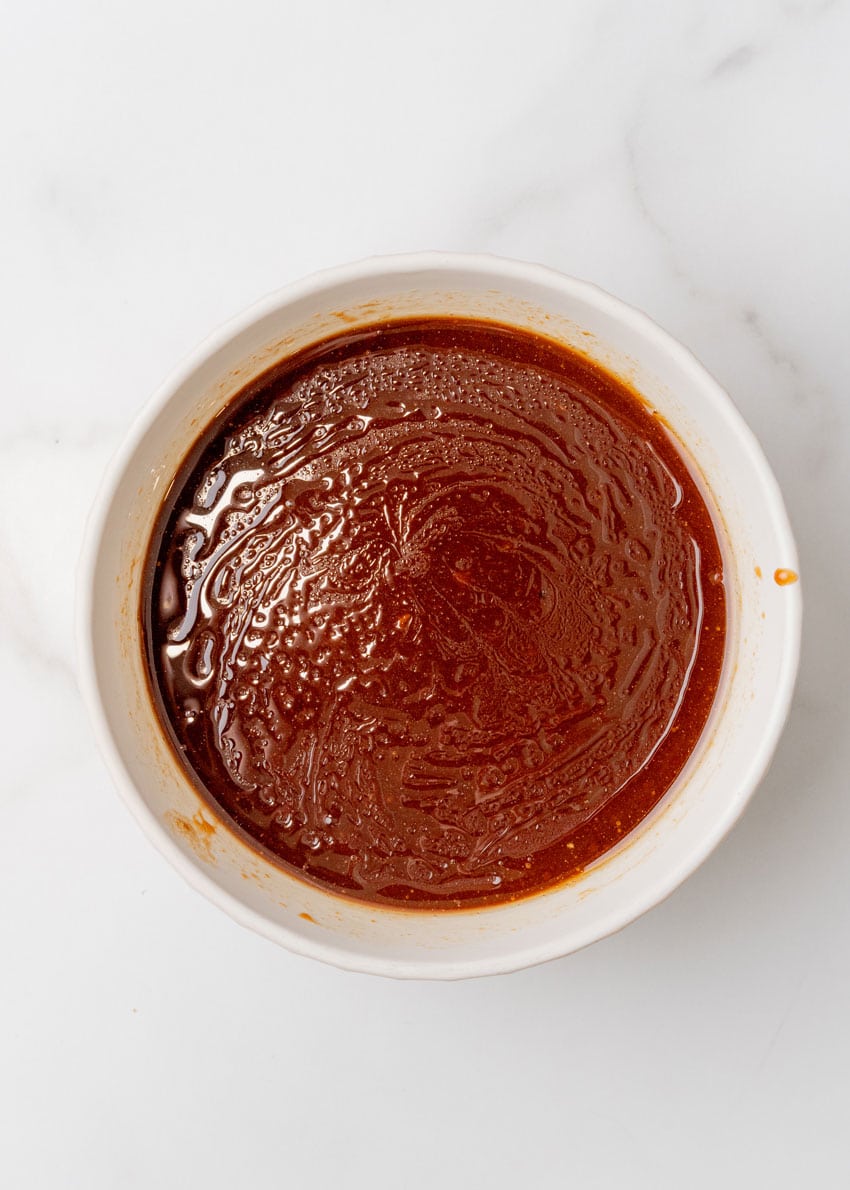 beijing beef sauce in a shallow white bowl