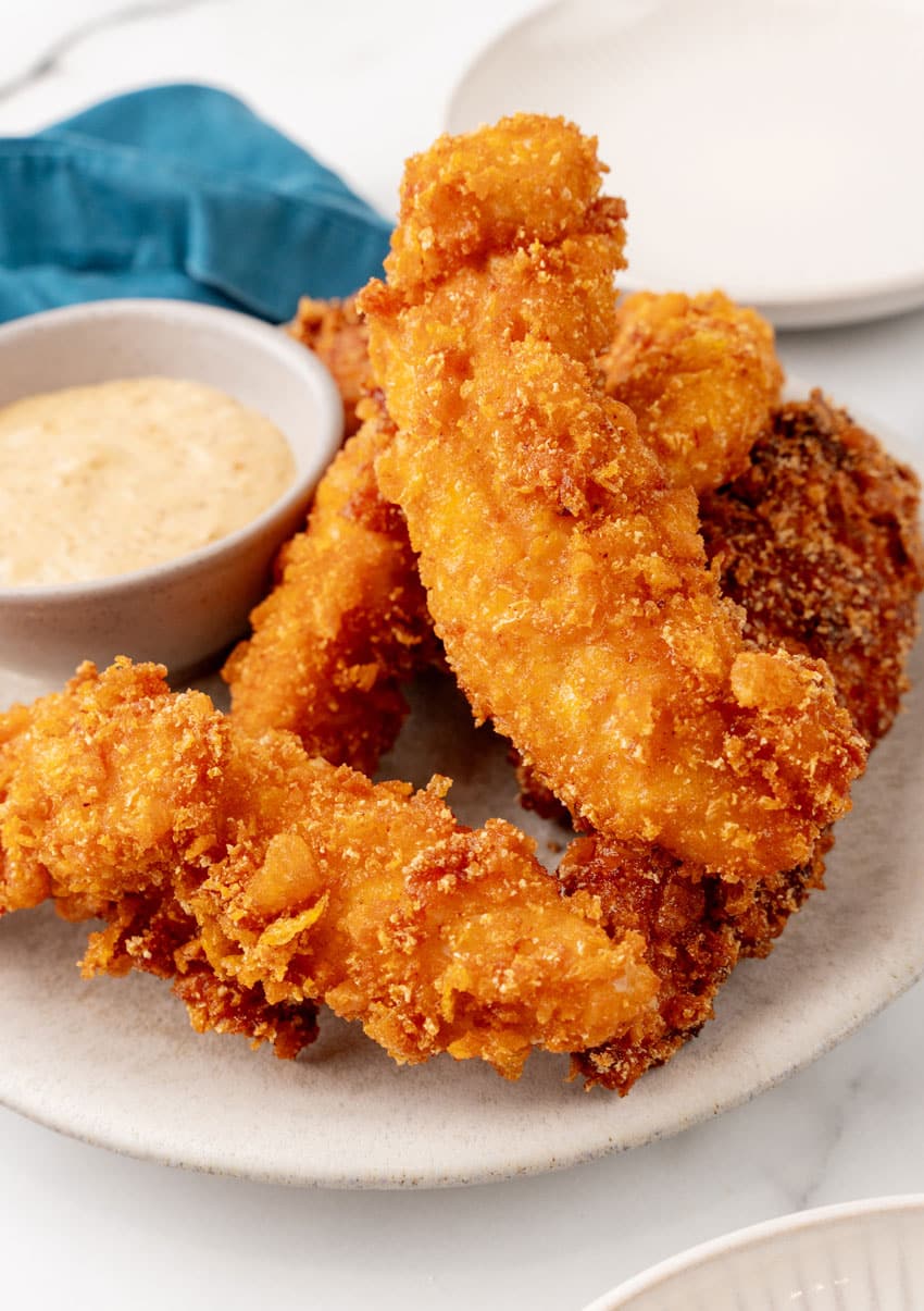 a pile of captain crunch chicken tenders on a white plate