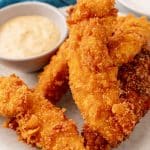 a pile of captain crunch chicken tenders on a white plate