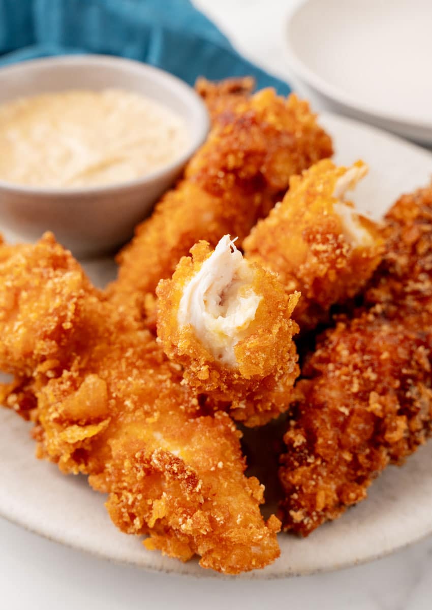 a pile of captain crunch chicken tenders on a white plate