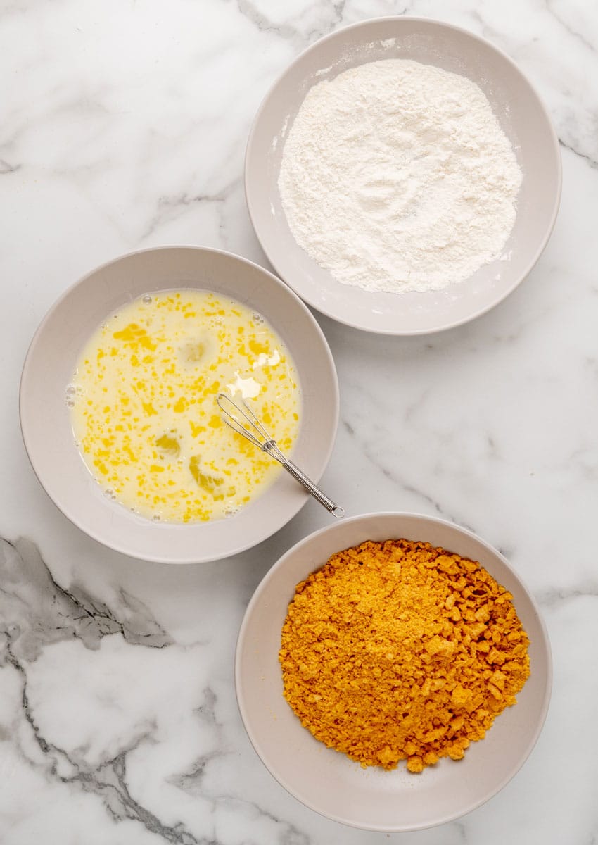 breading ingredients in three shallow white bowls