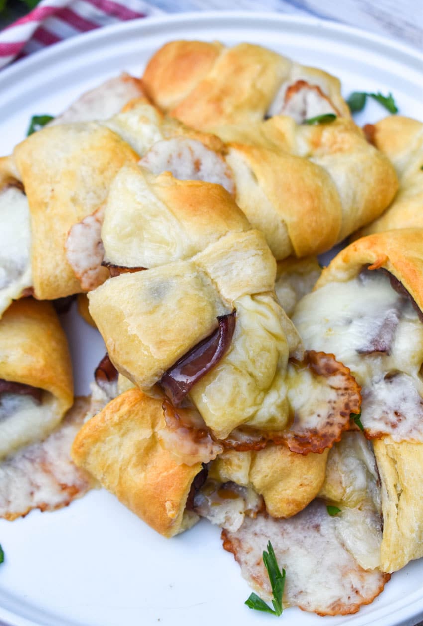 a pile of crescent roll french dips on a white plate