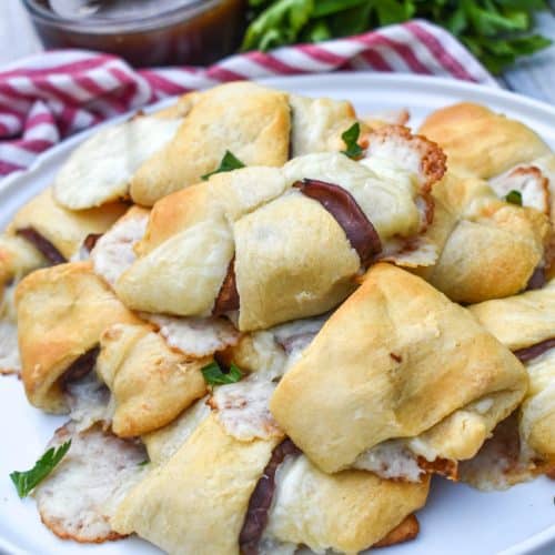 a pile of crescent roll french dips on a white plate