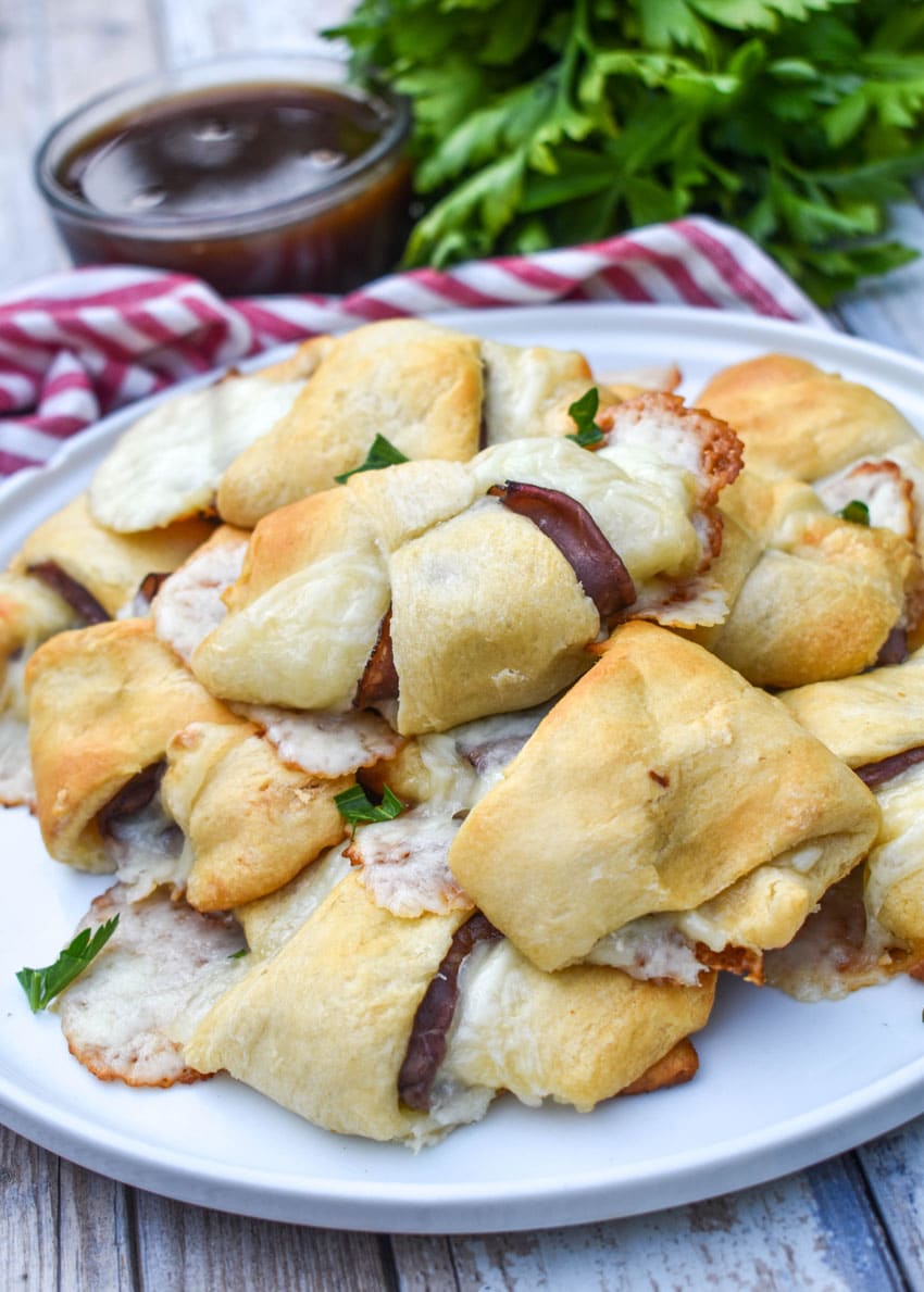 a pile of crescent roll french dips on a white plate