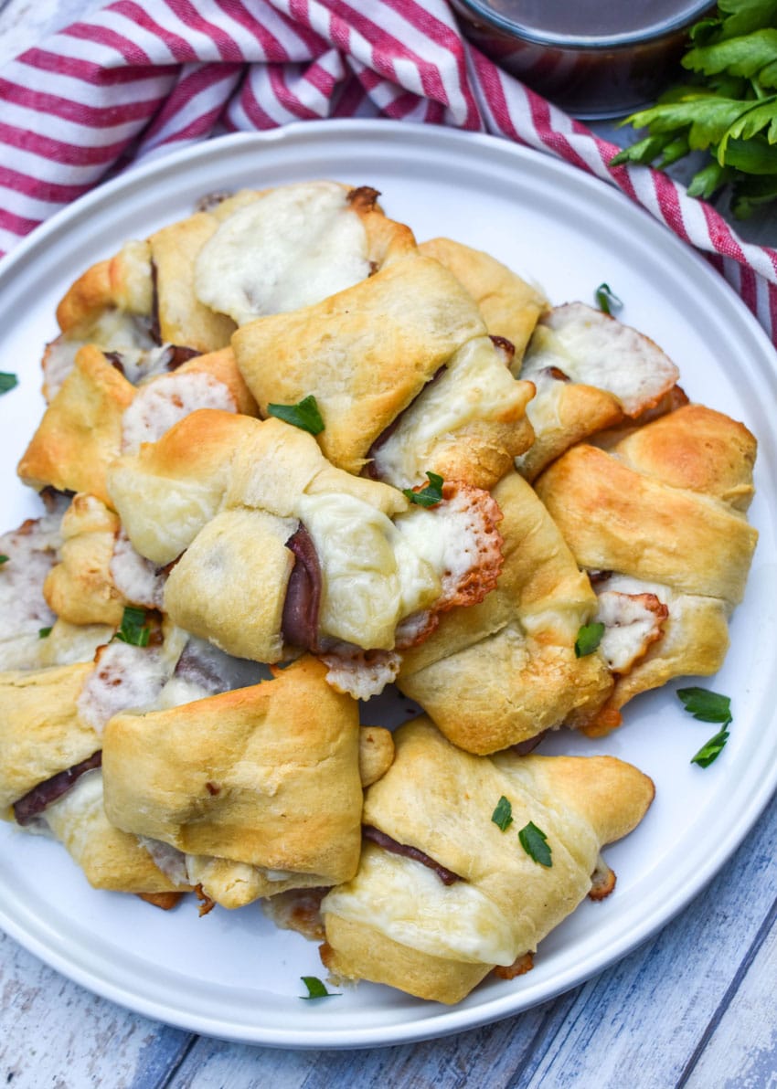 a pile of crescent roll french dips on a white plate