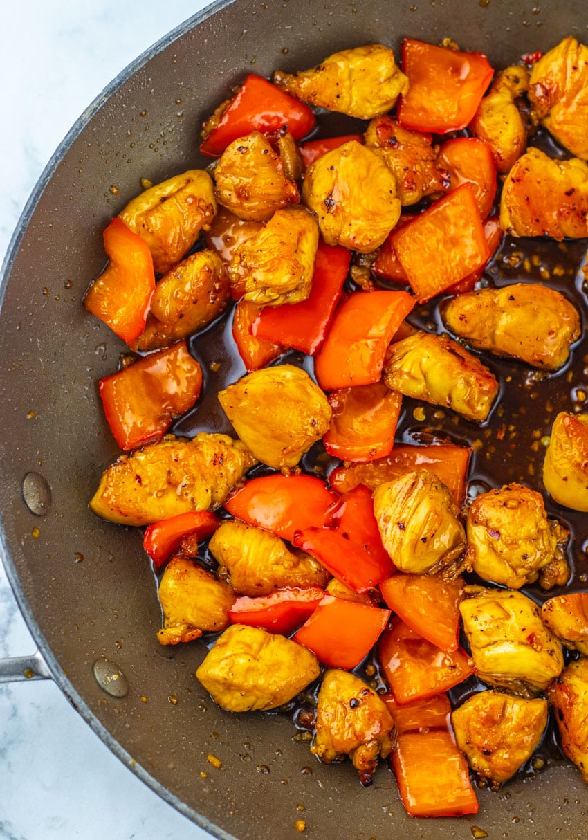 A CLOSE UP OF HONEY PEPPER CHICKEN IN A BLACK SKILLET