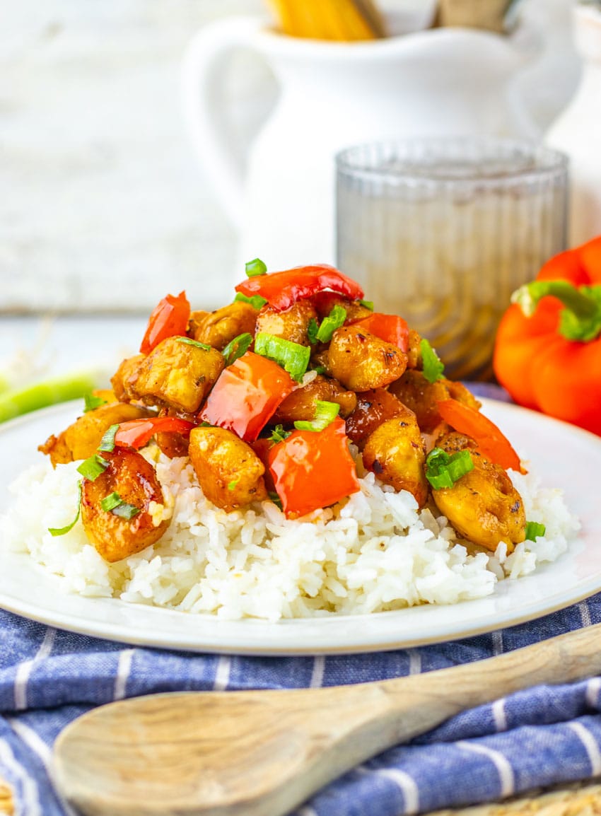 HONEY PEPPER CHICKEN OVER STEAMED WHITE RICE ON A WHITE PLATE