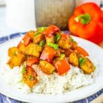 HONEY PEPPER CHICKEN OVER STEAMED WHITE RICE ON A WHITE PLATE