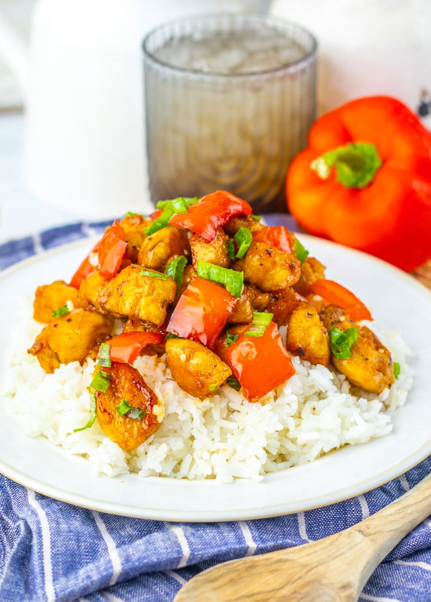 HONEY PEPPER CHICKEN OVER STEAMED WHITE RICE ON A WHITE PLATE