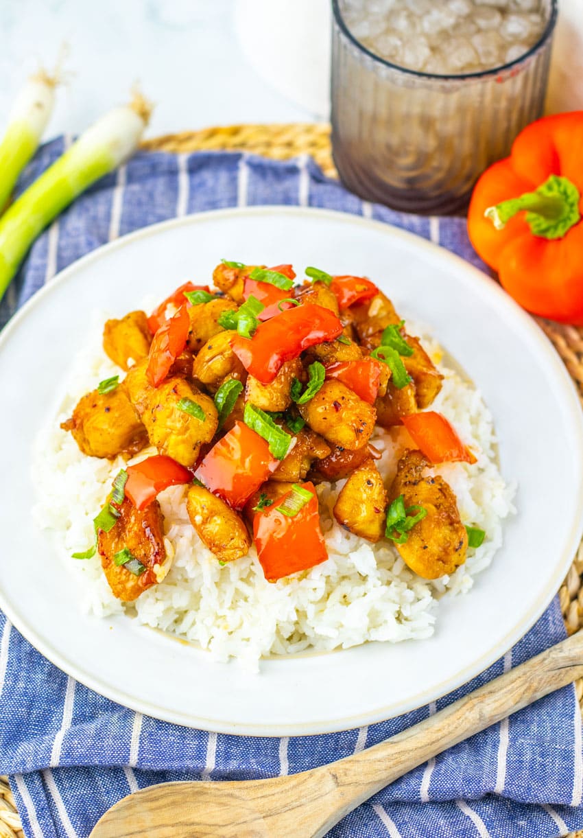 HONEY PEPPER CHICKEN OVER STEAMED WHITE RICE ON A WHITE PLATE