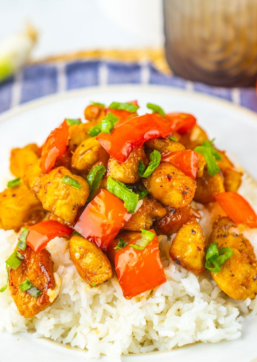 HONEY PEPPER CHICKEN OVER STEAMED WHITE RICE ON A WHITE PLATE