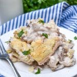 biscuits and gravy skillet on a small white plate with a silver fork resting on the side