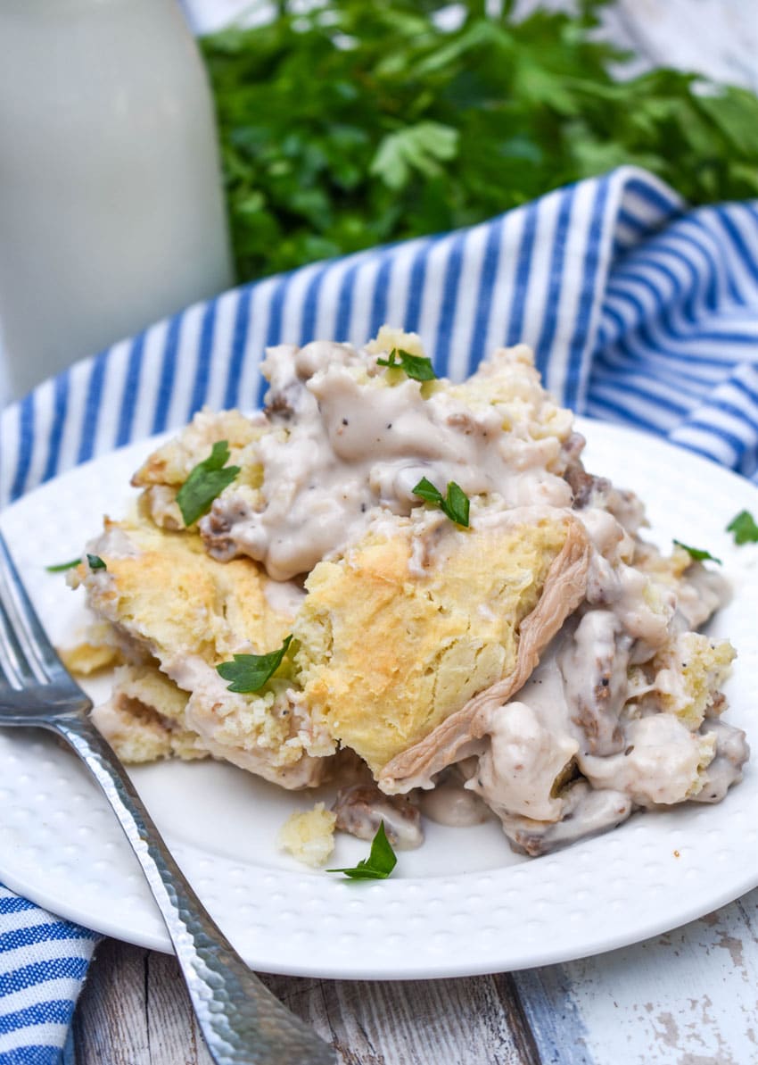 biscuits and gravy skillet on a small white plate with a silver fork resting on the side