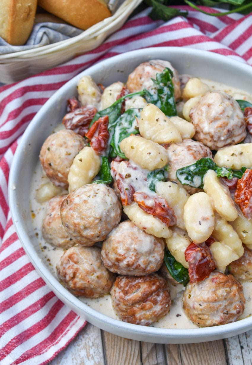 slow cooker marry me meatballs with gnocchi in a shallow white bowl
