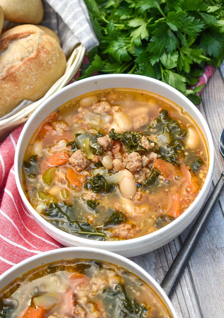 tuscan white bean soup with kale in two white bowls