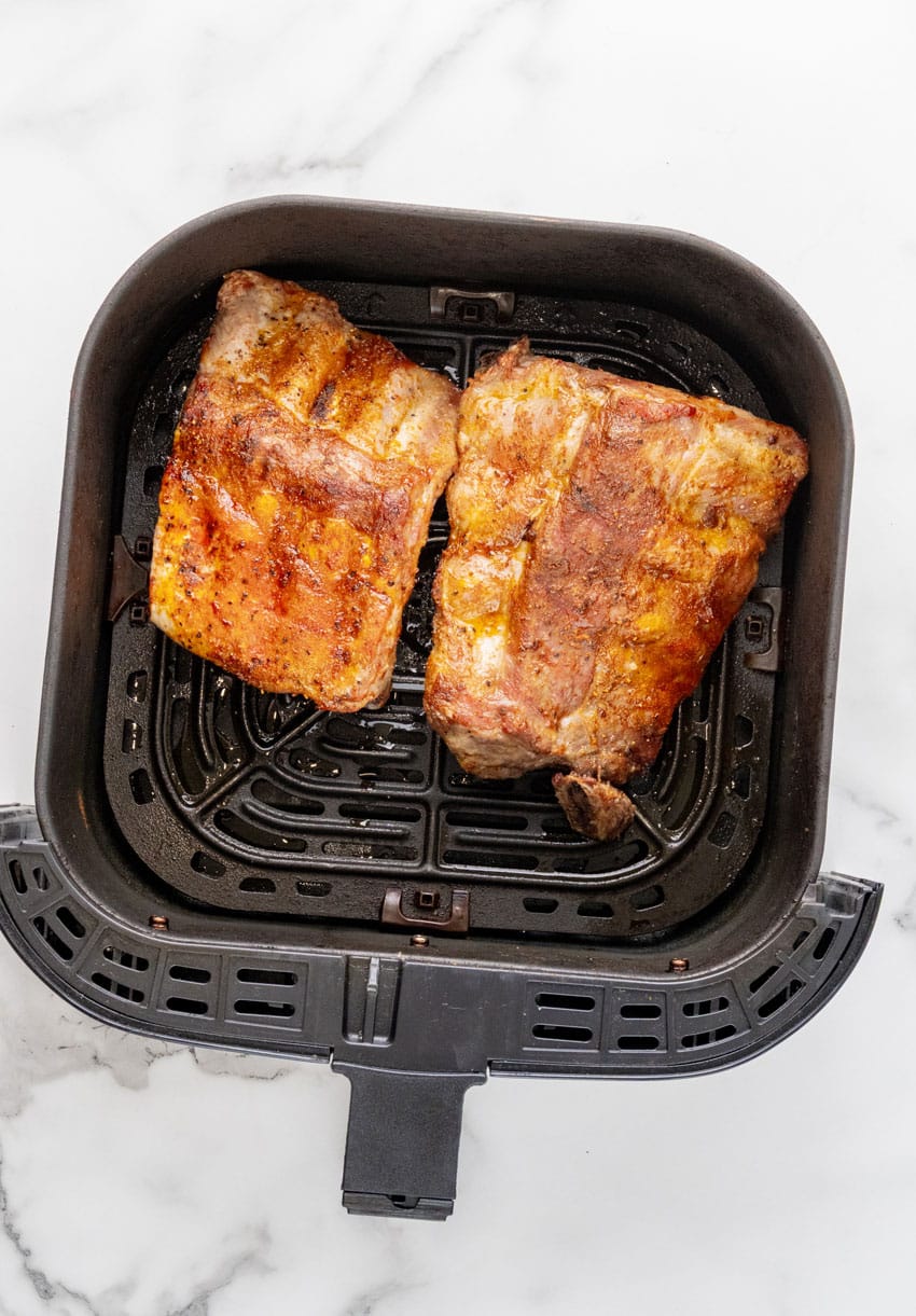 cooked ribs in the basket of an air fryer