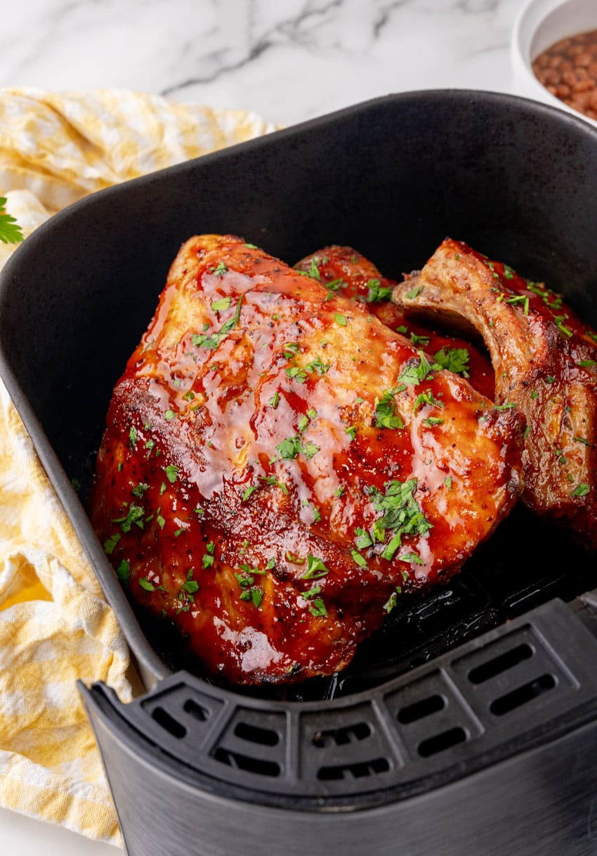 sauced ribs in the basket of an air fryer