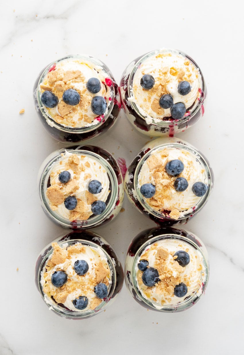 blueberry cheesecake jars arranged in two rows on a marble countertop