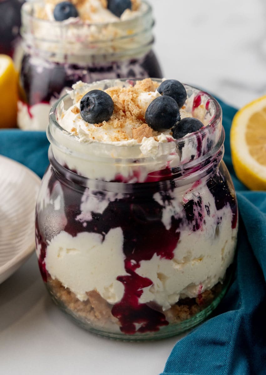 a close up of a blueberry cheesecake jar