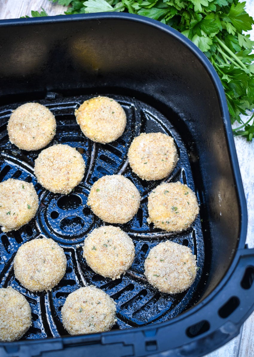 breaded babybell cheese in the basket of an air fryer