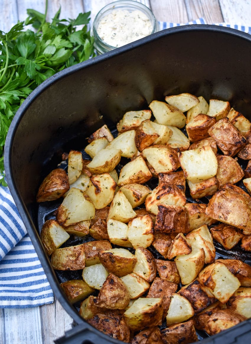 crispy ranch potatoes in the black basket of an air fryer