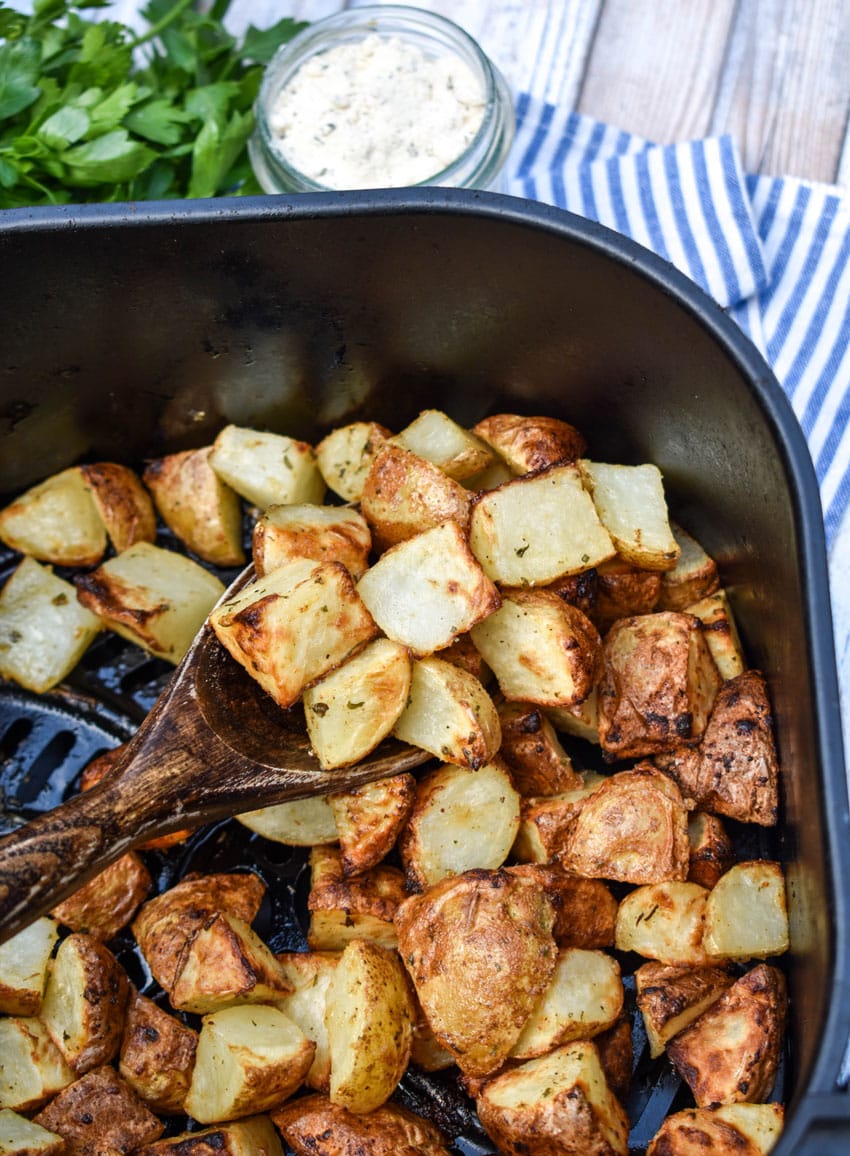 crispy ranch potatoes in the black basket of an air fryer