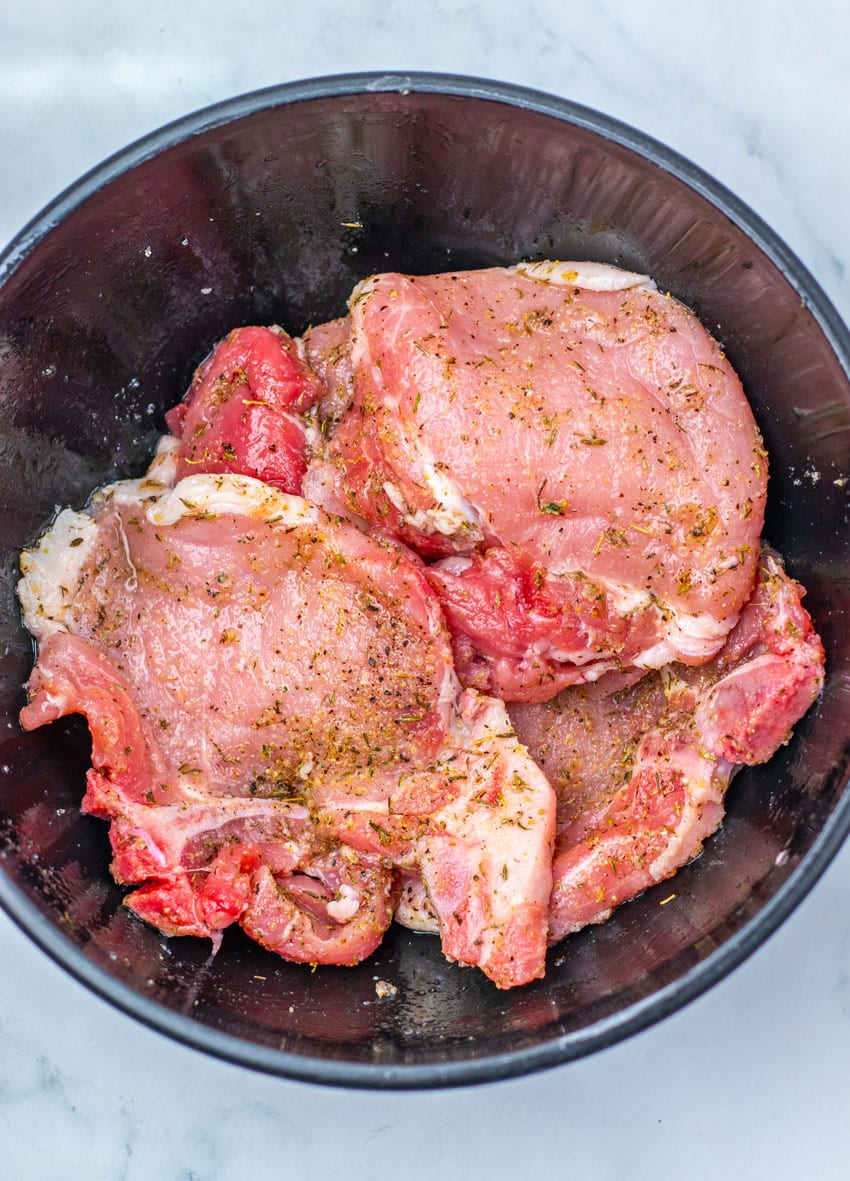 seasoned pork chops in a large metal mixing bowl