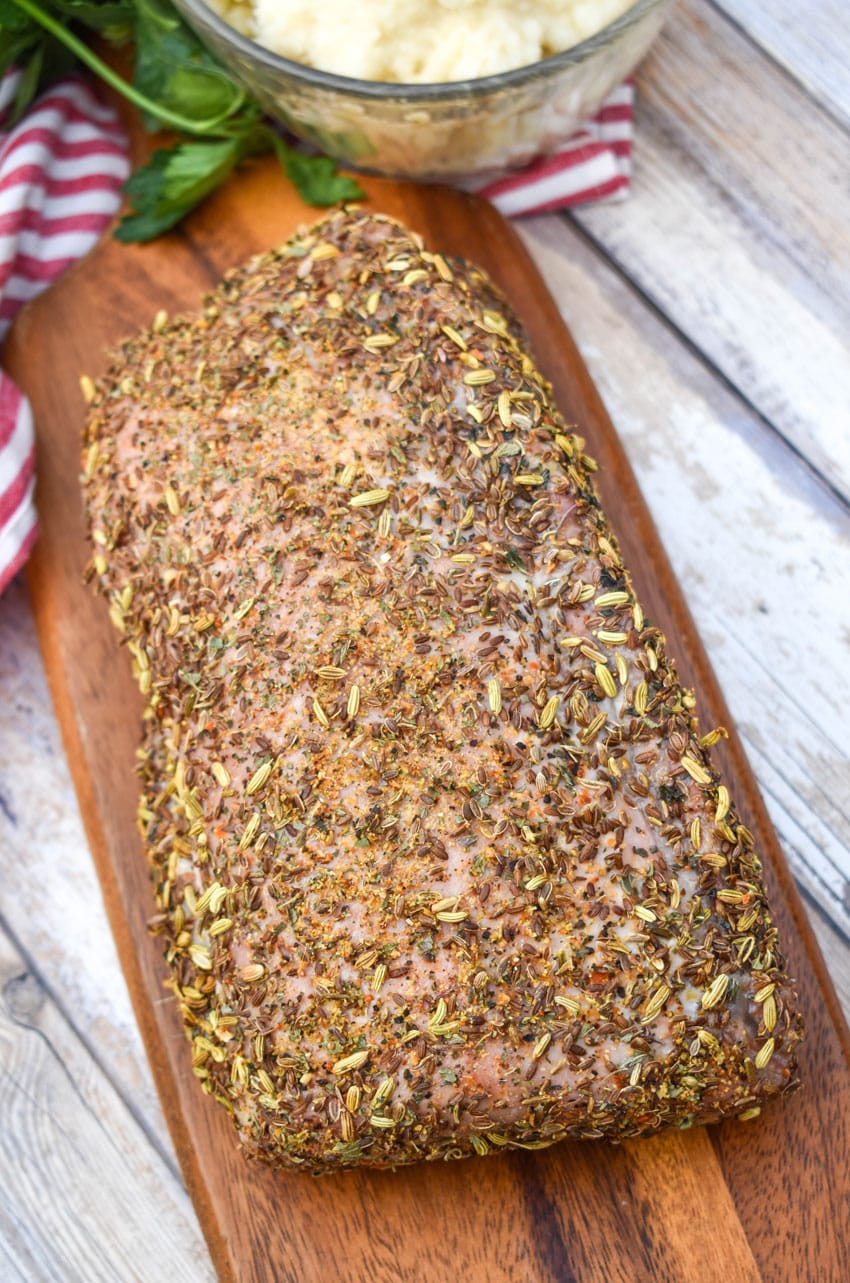 a close up of Italian porchetta on a wooden cutting board