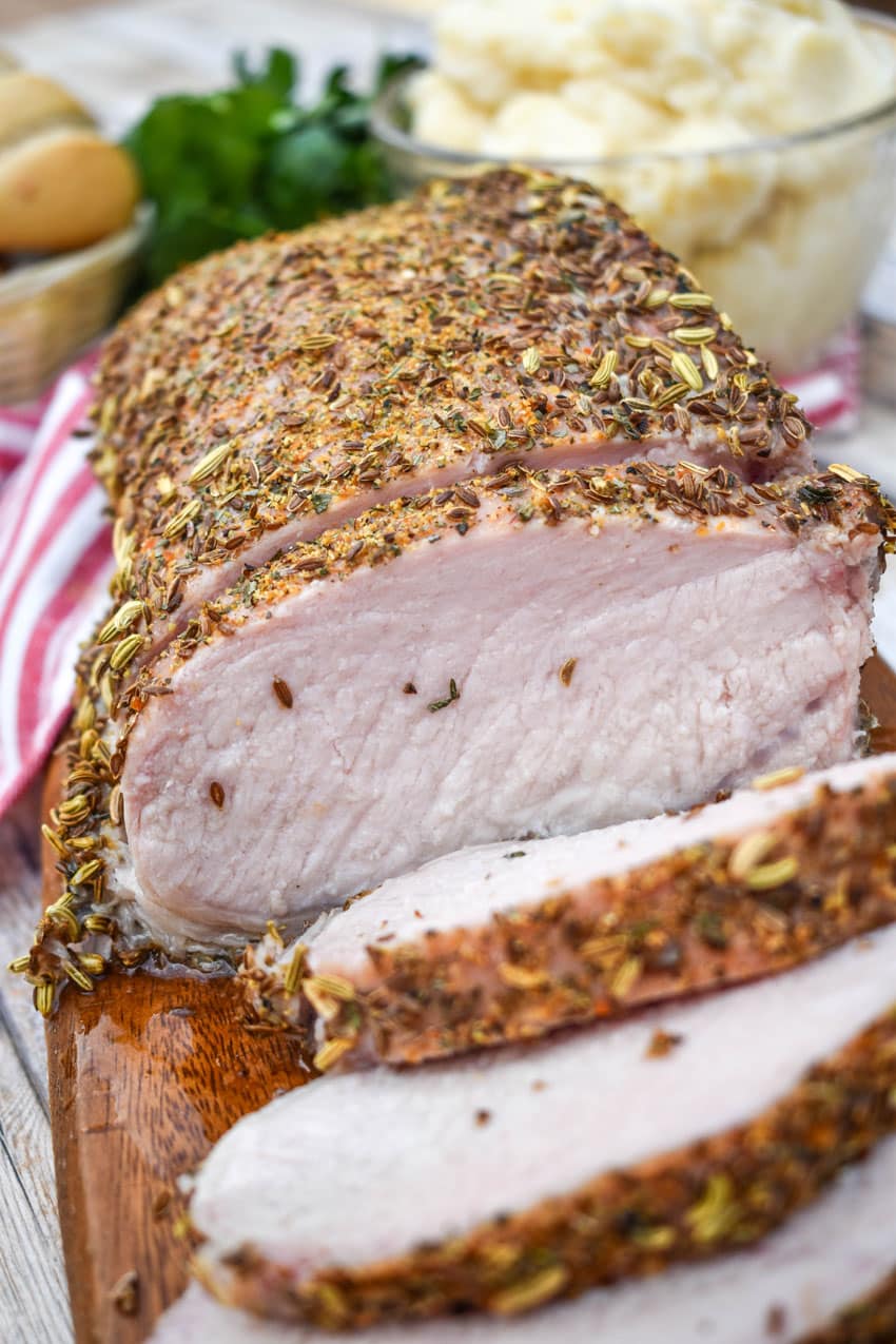 slices of Italian porketta on a wooden cutting board