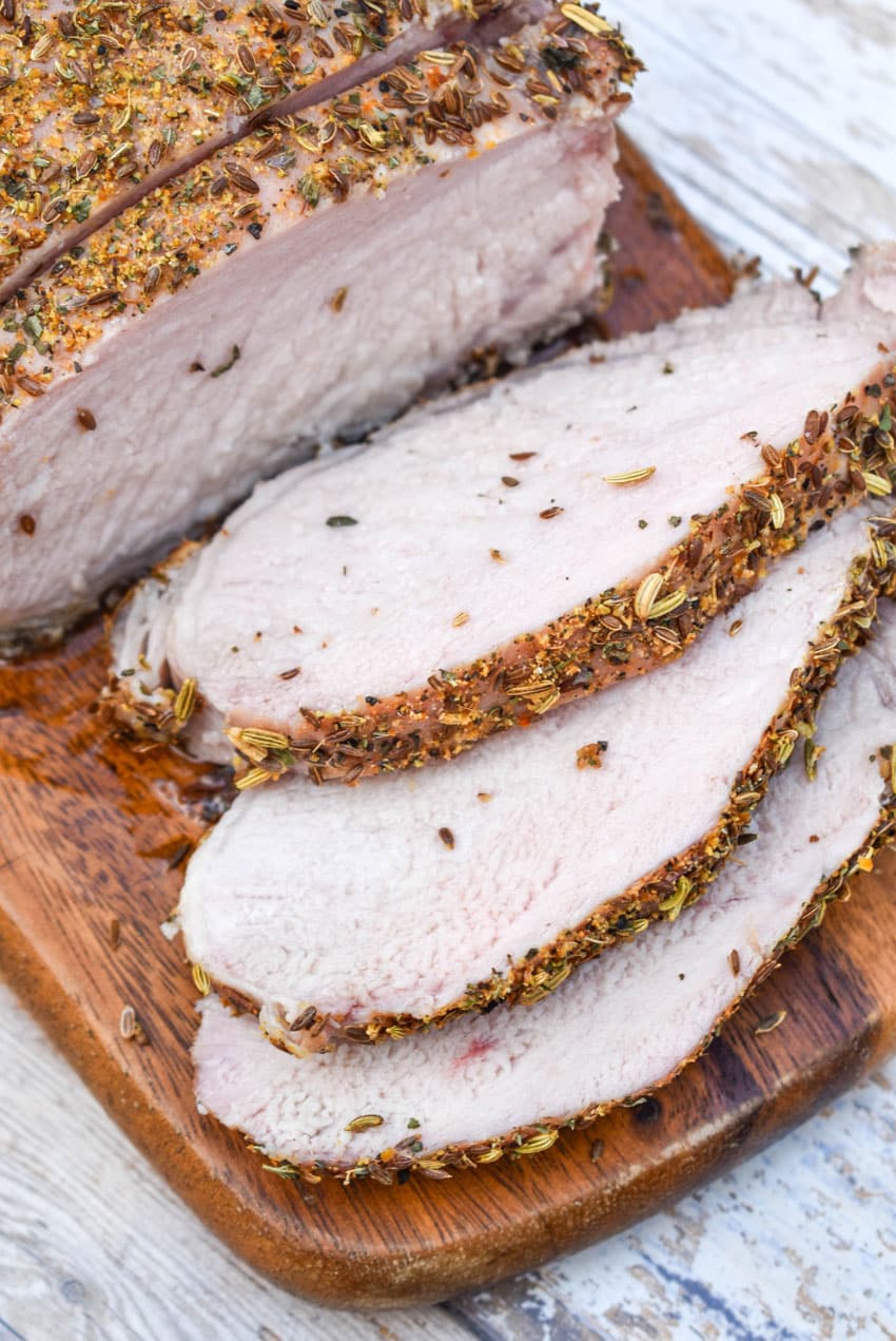 slices of Italian porketta on a wooden cutting board