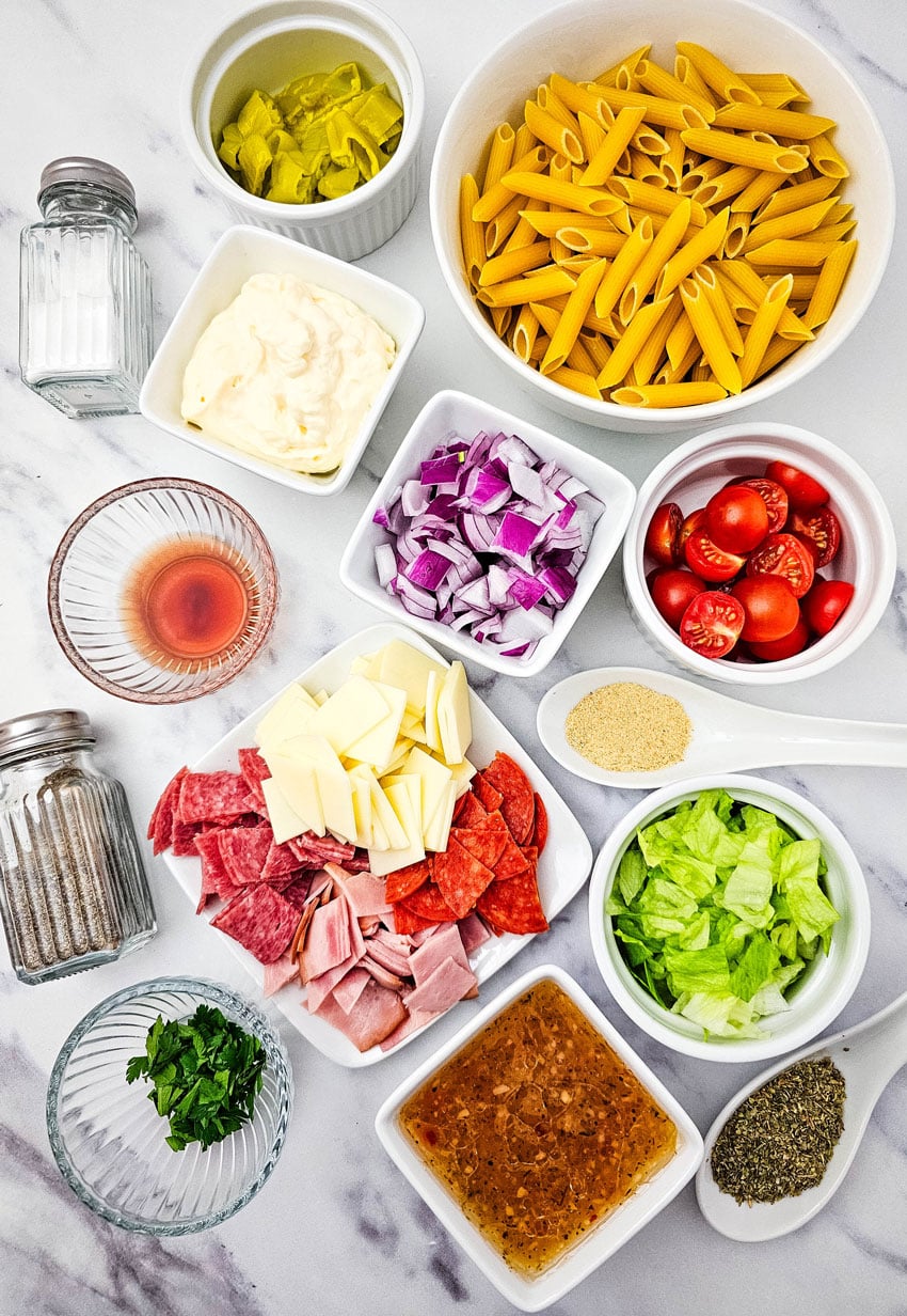 an overhead image showing the measured ingredients needed to make a batch of Italian hoagie pasta salad