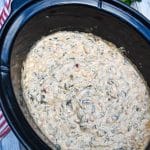 mexican spinach dip in the black bowl of a slow cooker