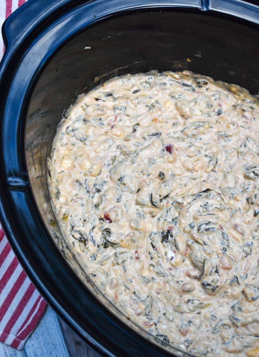mexican spinach dip in the black bowl of a slow cooker