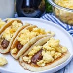 pancake breakfast tacos arranged in a row on a white serving plate