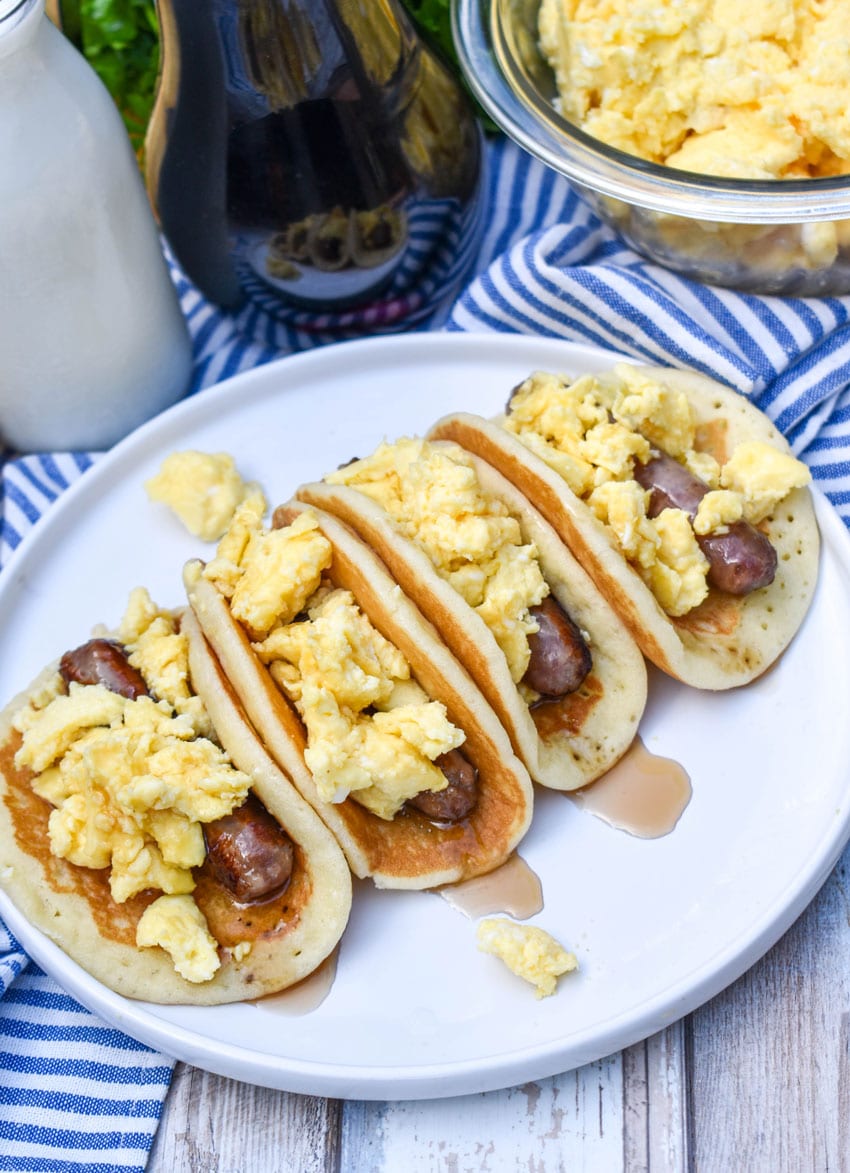 pancake breakfast tacos arranged in a row on a white serving plate