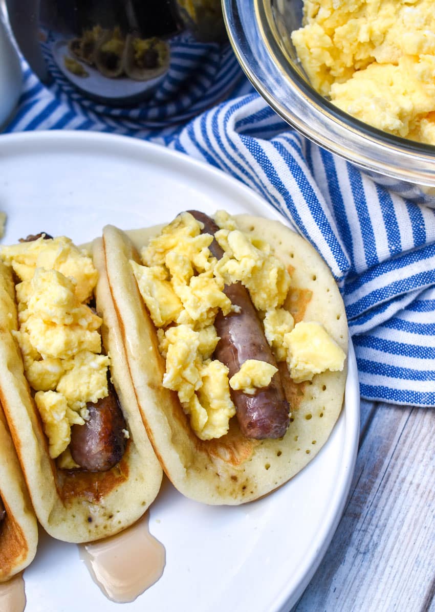 pancake breakfast tacos arranged in a row on a white serving plate
