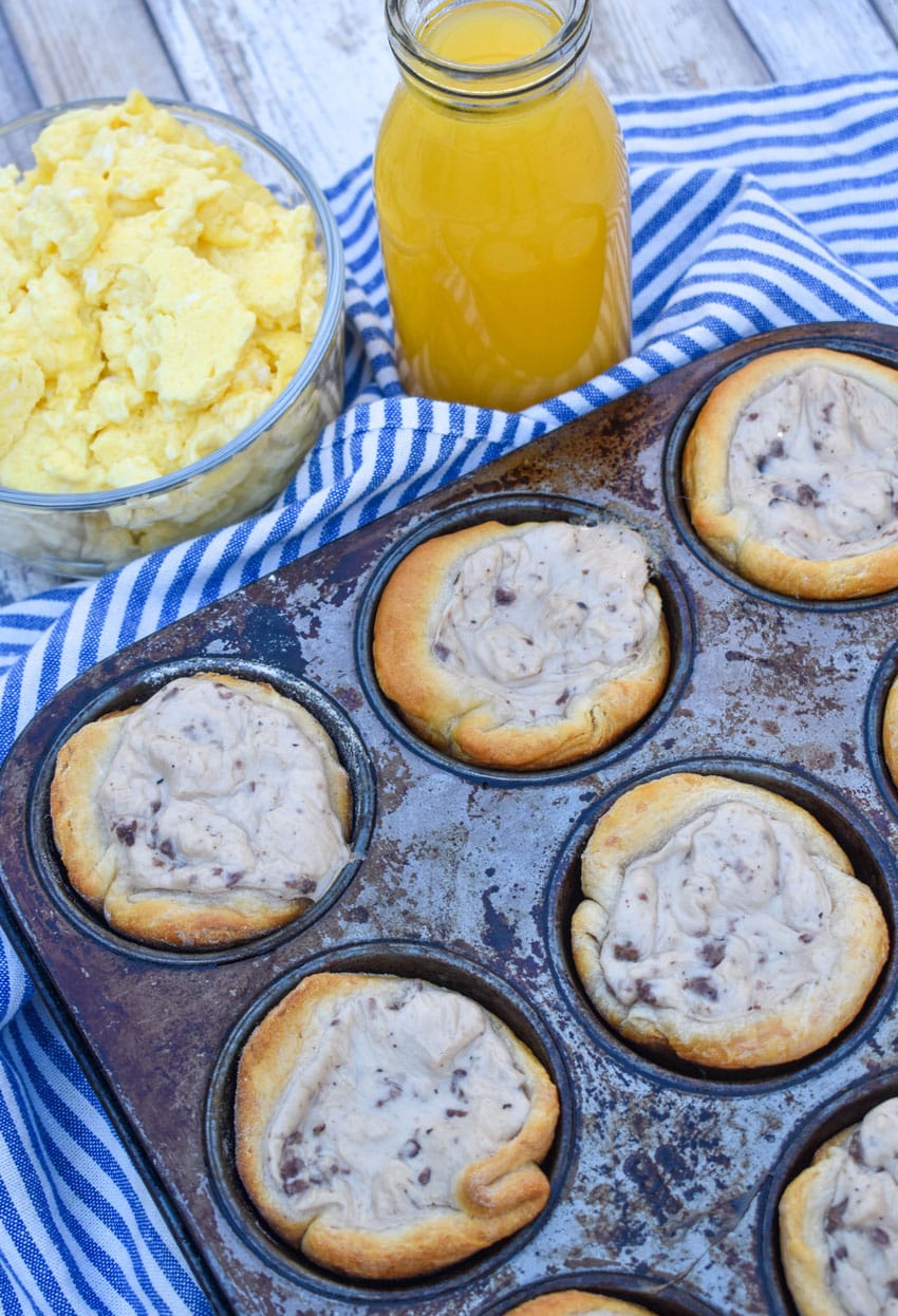 sausage gravy biscuit cups in a metal muffin tin