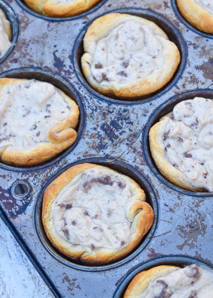 sausage gravy biscuit cups in a metal muffin tin