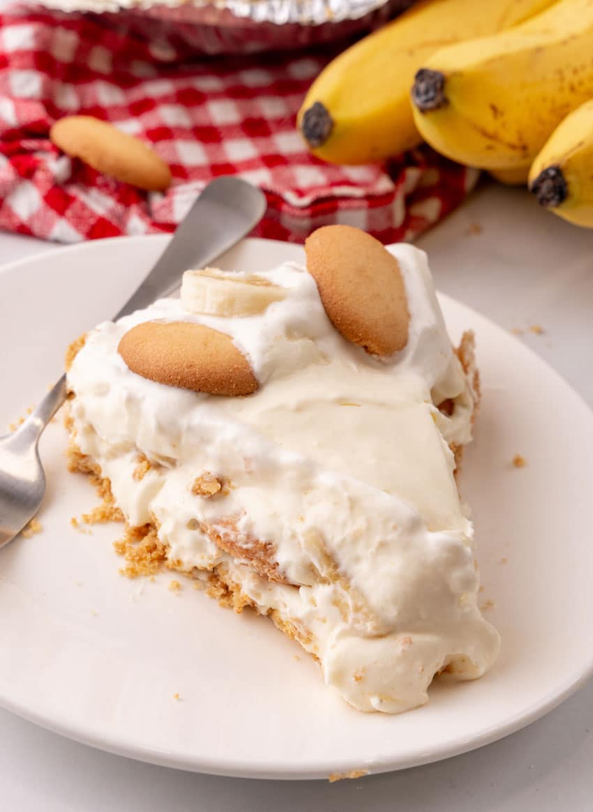 a slice of banana cream pie on a white dessert plate