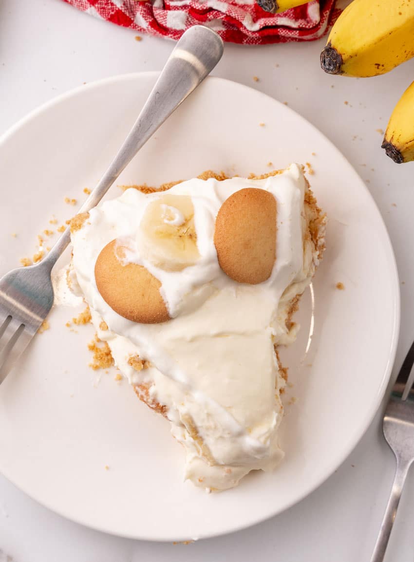 a slice of banana cream pie on a white dessert plate