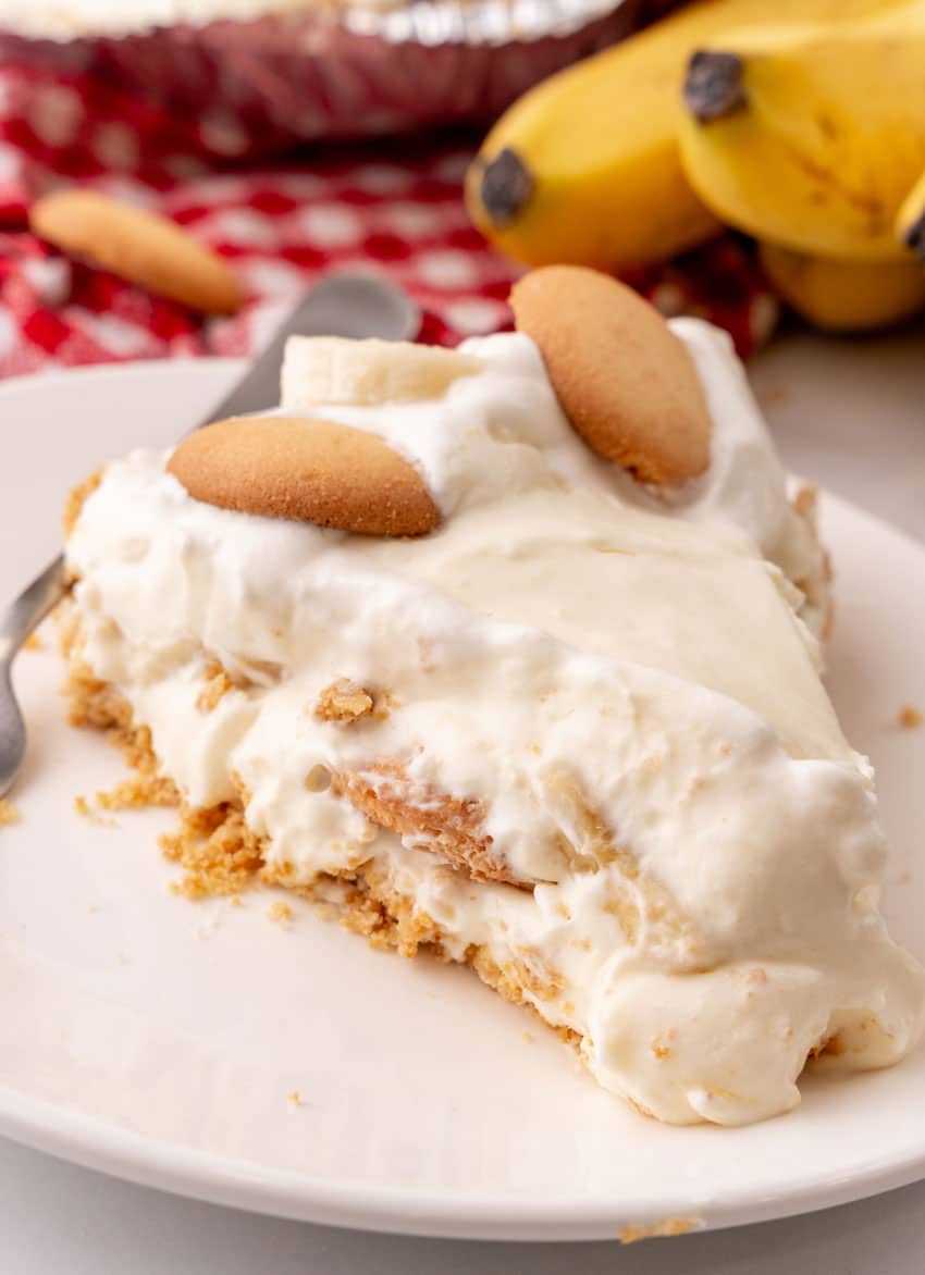 a slice of banana cream pie on a white dessert plate