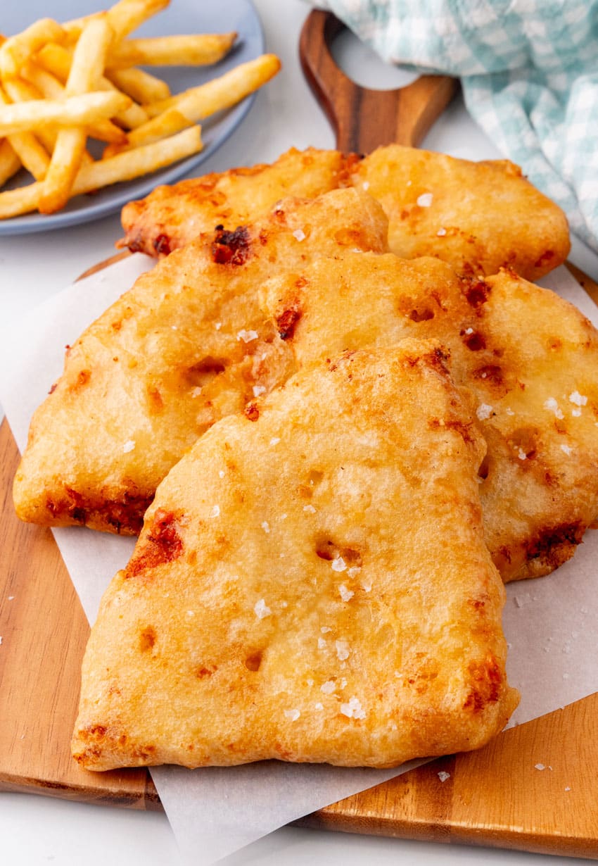 slices of pizza crunch on a parchment paper lined wooden cutting board