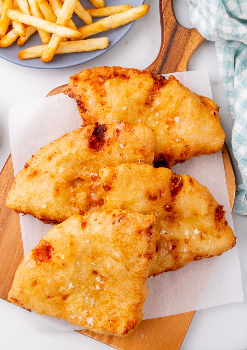 slices of pizza crunch on a parchment paper lined wooden cutting board
