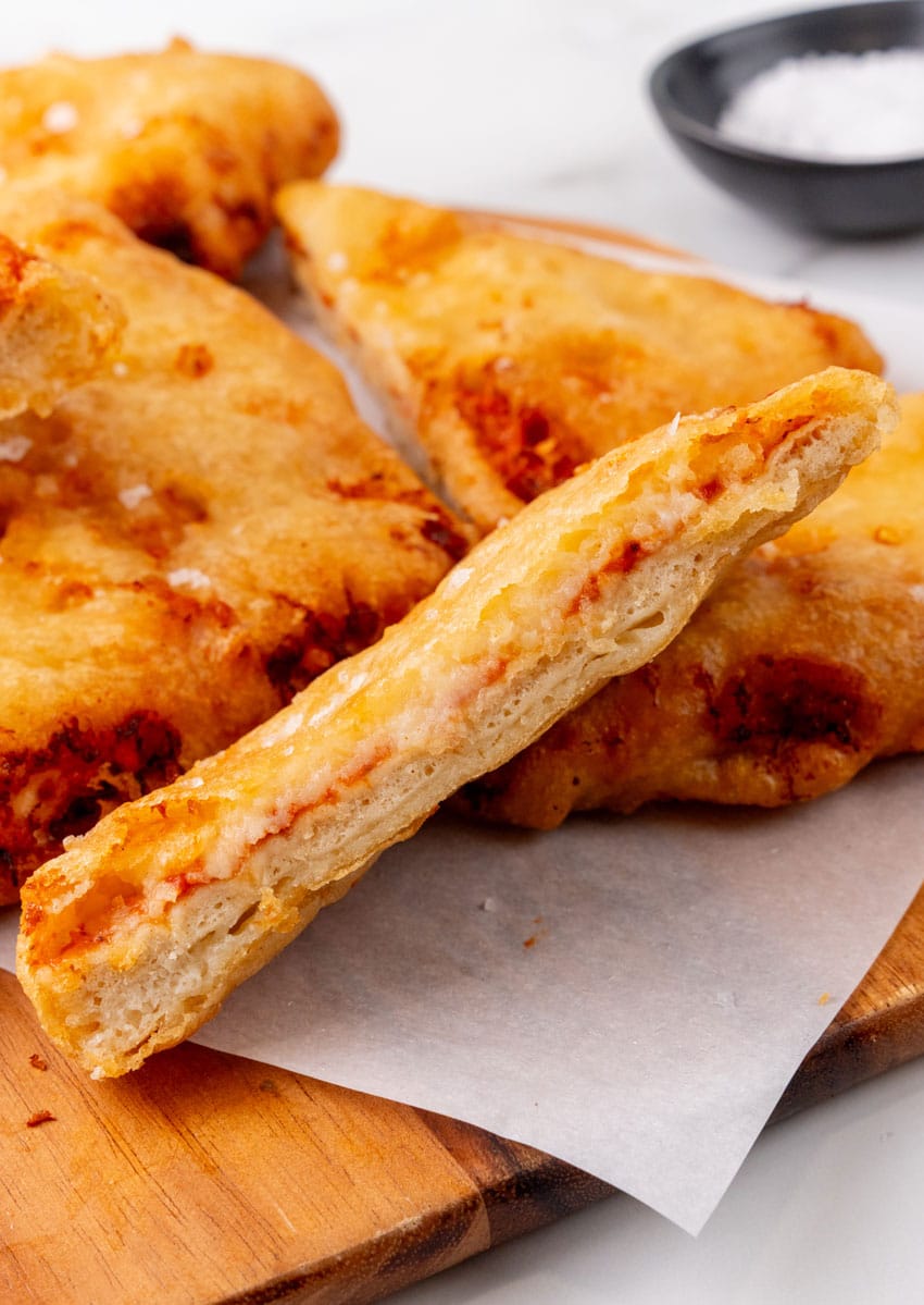 slices of pizza crunch on a parchment paper lined wooden cutting board